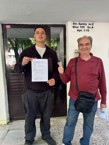 Operator Compania DDD la intrarea unui bloc, cu procesul-verbal semnat de reprezentantul asociației