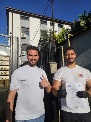 Operator Compania DDD la intrarea unui bloc, cu procesul-verbal semnat de reprezentantul asociației