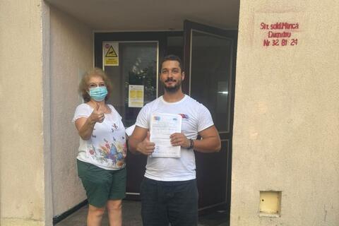 Operator Compania DDD la intrarea unui bloc, cu procesul-verbal semnat de reprezentantul asociației