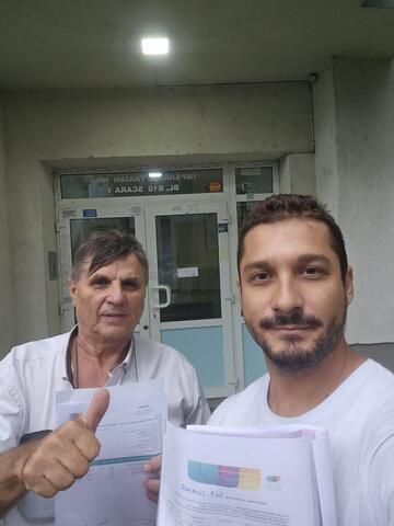 Operator Compania DDD la intrarea unui bloc, cu procesul-verbal semnat de reprezentantul asociației