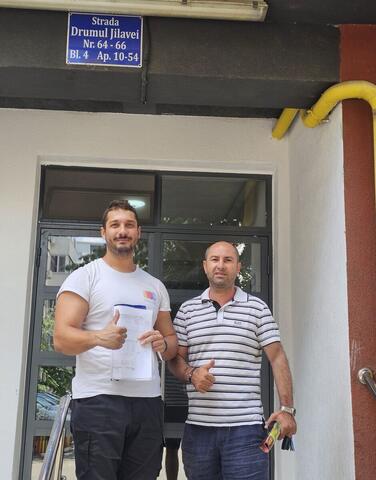 Operator Compania DDD la intrarea unui bloc, cu procesul-verbal semnat de reprezentantul asociației