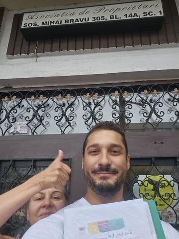 Operator Compania DDD la intrarea unui bloc, cu procesul-verbal semnat de reprezentantul asociației
