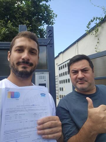 Operator Compania DDD la intrarea unui bloc, cu procesul-verbal semnat de reprezentantul asociației