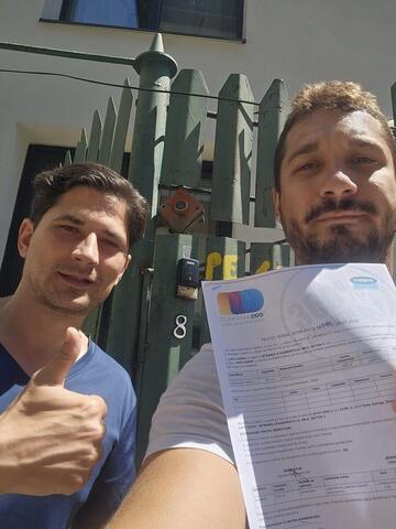 Operator Compania DDD la intrarea unui bloc, cu procesul-verbal semnat de reprezentantul asociației