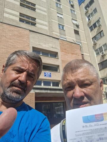 Operator Compania DDD la intrarea unui bloc, cu procesul-verbal semnat de reprezentantul asociației