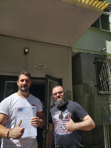 Operator Compania DDD la intrarea unui bloc, cu procesul-verbal semnat de reprezentantul asociației