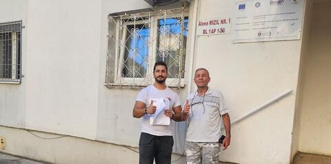 Operator Compania DDD la intrarea unui bloc, cu procesul-verbal semnat de reprezentantul asociației