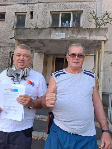 Operator Compania DDD la intrarea unui bloc, cu procesul-verbal semnat de reprezentantul asociației
