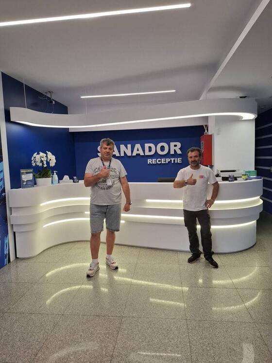Coleg Compania DDD în tricou cu siglă, alături de un reprezentant al clientului, la recepția unei clinici Sanador