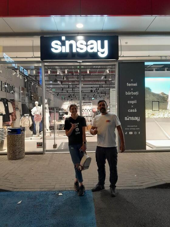 Operator Compania DDD alături de o angajată a magazinului, în fața unui Sinsay